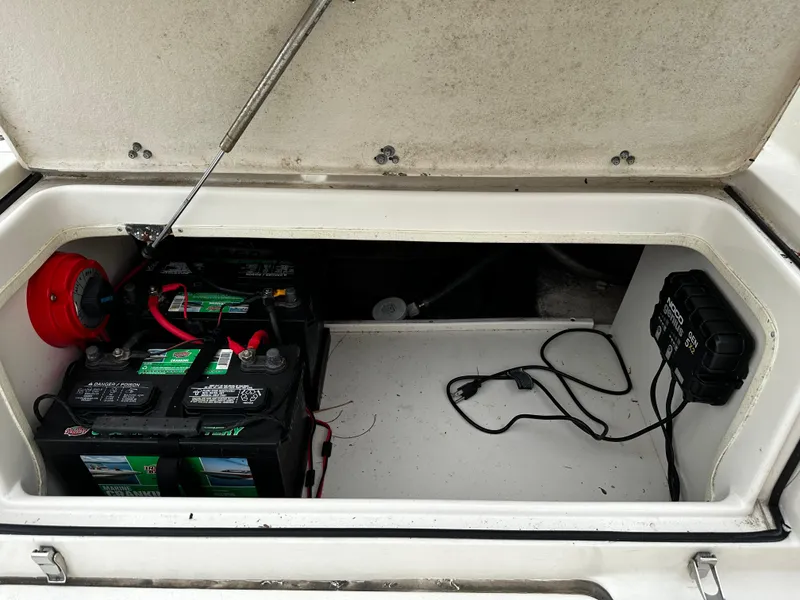 Slide: The Image of An open storage compartment on a boat reveals two batteries and electrical wiring. - 27