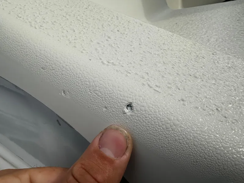 Slide: The Image of Close-up of a damaged part of a boat with a small dent or hole. - 10
