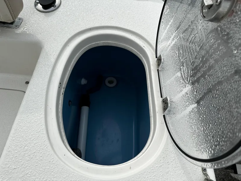 Slide: The Image of An open, oval compartment on a boat with a blue interior and a lid. - 24