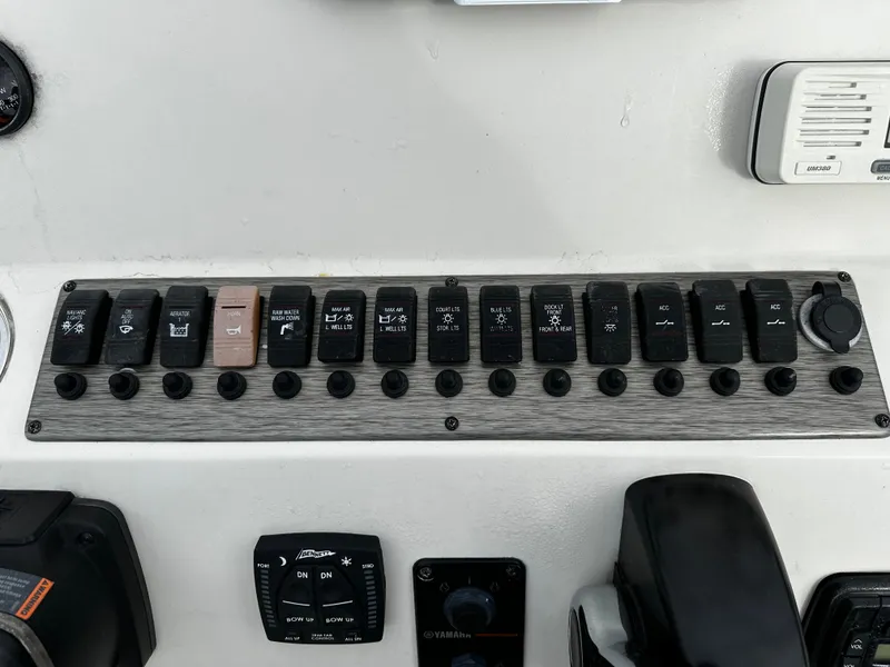 Slide: The Image of The image shows a control panel with multiple toggle switches and gauges on a boat. - 46
