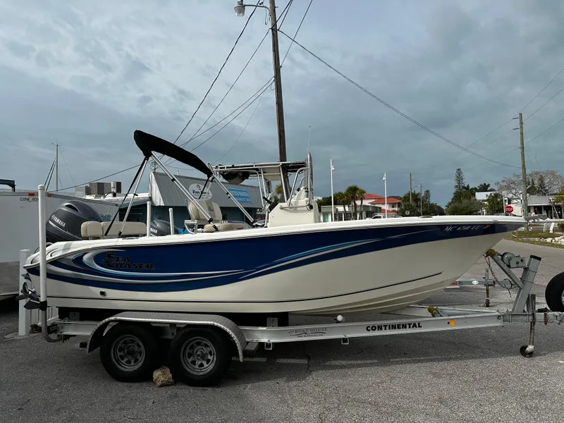 Slide: The Image of 2016 Sea Chaser 20 HFC on a trailer, featuring a blue stripe and bimini top. - 2
