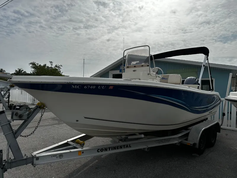 Slide: The Image of A 2016 Sea Chaser 20 HFC boat on a trailer, featuring blue and white paint. - 1