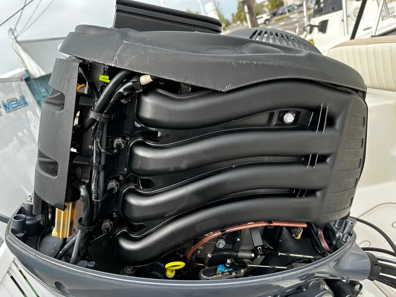Slide: The Image of Close-up of an outboard motor with visible components and hoses, mounted on a boat. - 20