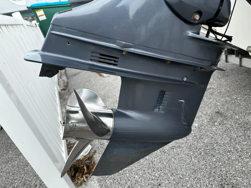 Slide: The Image of Close-up of an outboard motor with propeller, mounted on a boat, in a parking area. - 14