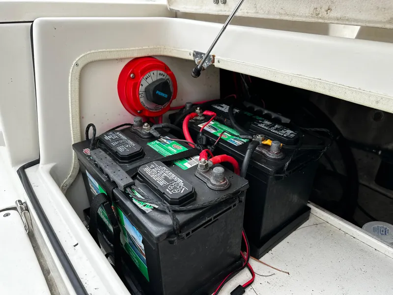 Slide: The Image of Battery compartment with two car batteries and a red switch in a boat. - 28