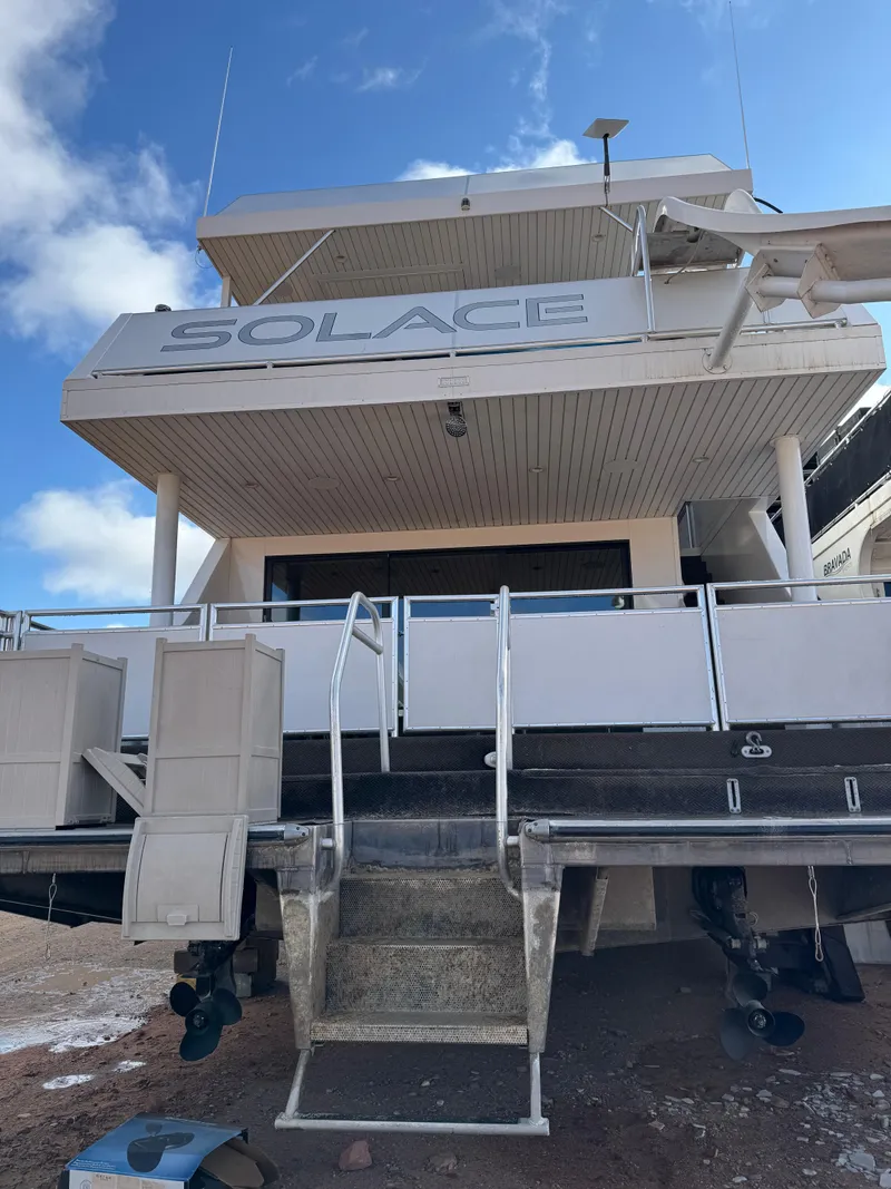Slide: The Image of Luxury yacht "Adonia Solace Trip #16" docked, rear view, 2021 model, under a clear sky. - 16