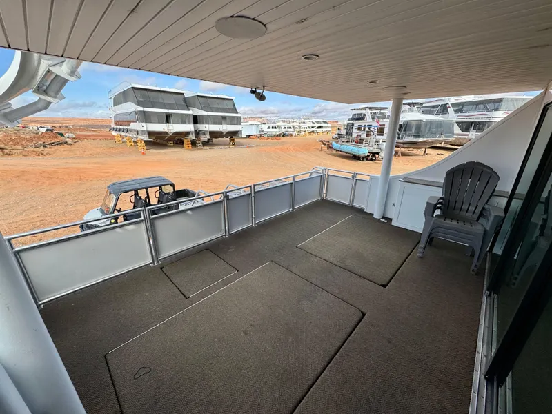 Slide: The Image of Deck view of Adonia Solace Trip #16, 2021, with parked vehicles and houseboats in the background. - 15