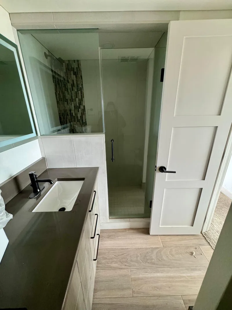 Slide: The Image of Modern bathroom with glass shower, sleek vanity, and wooden flooring in Adonia Solace Trip #16. - 21