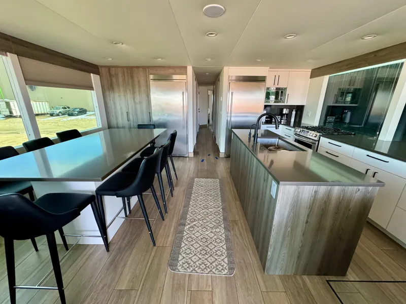 Slide: The Image of Modern kitchen interior in Adonia Solace Trip #16, 2021, featuring sleek countertops and dining area. - 13