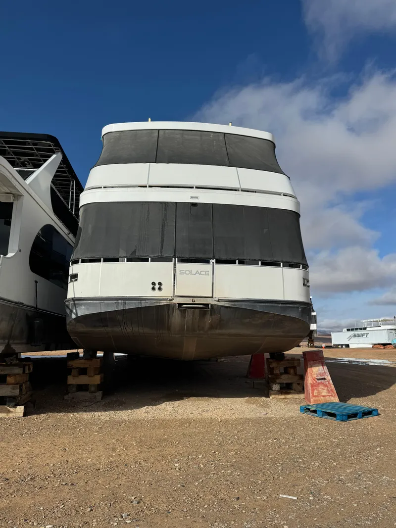 The Image of Houseboat Adonia Solace Share #15, 2021 model, docked on land under a clear blue sky. - 0