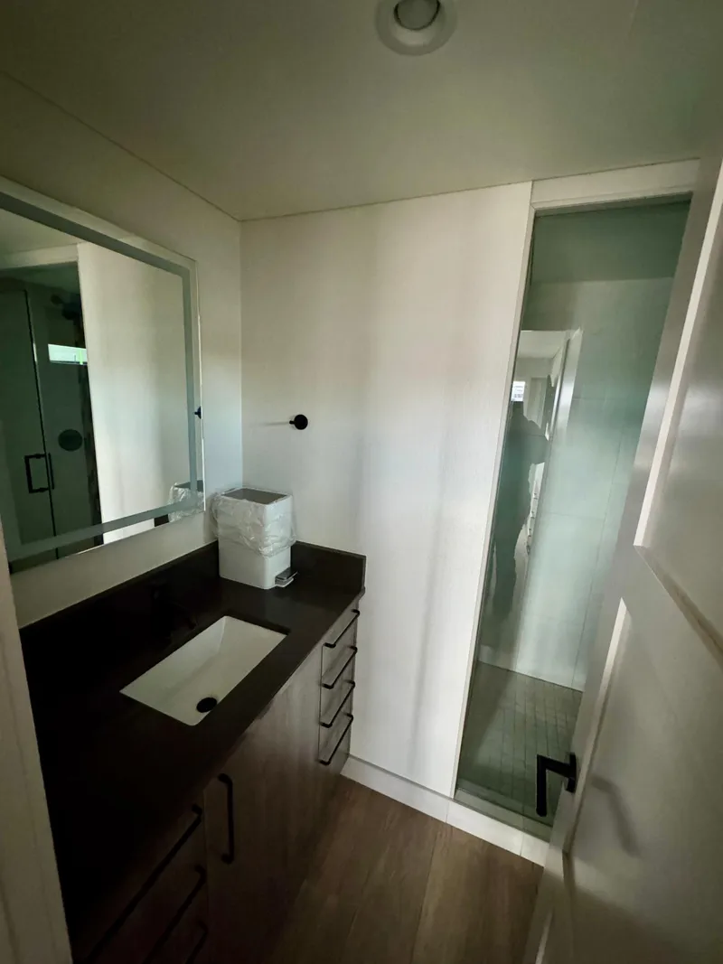 Slide: The Image of Modern bathroom in Adonia Solace Trip #16, 2021 model, featuring sleek vanity and glass shower. - 11