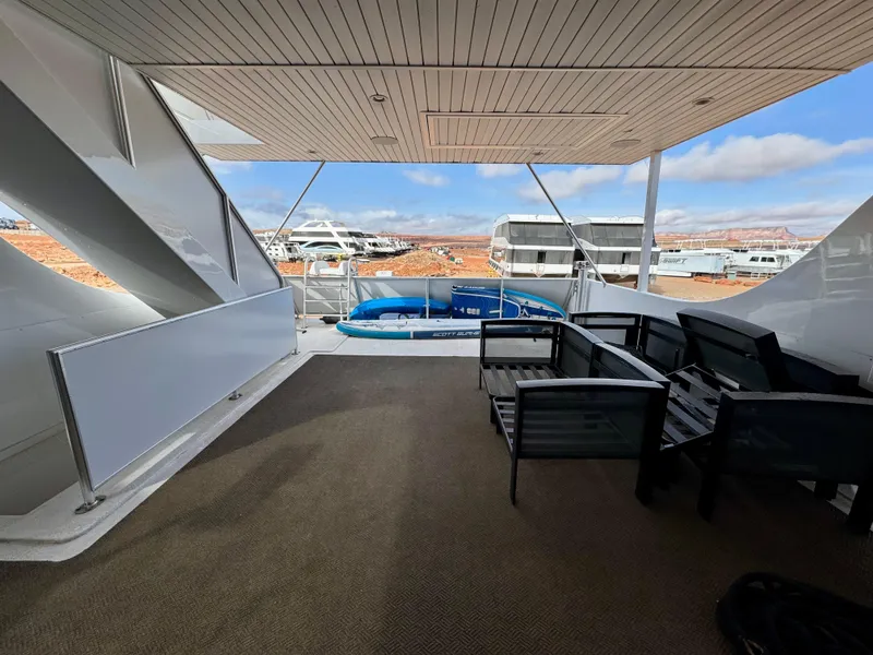 Slide: The Image of Outdoor deck of Adonia Solace Trip #16 houseboat, featuring seating and scenic marina view. - 26