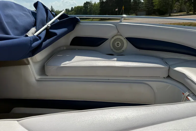 Slide: The Image of Interior of a 2013 Crownline 21 SS boat with white seating and blue cover. - 17