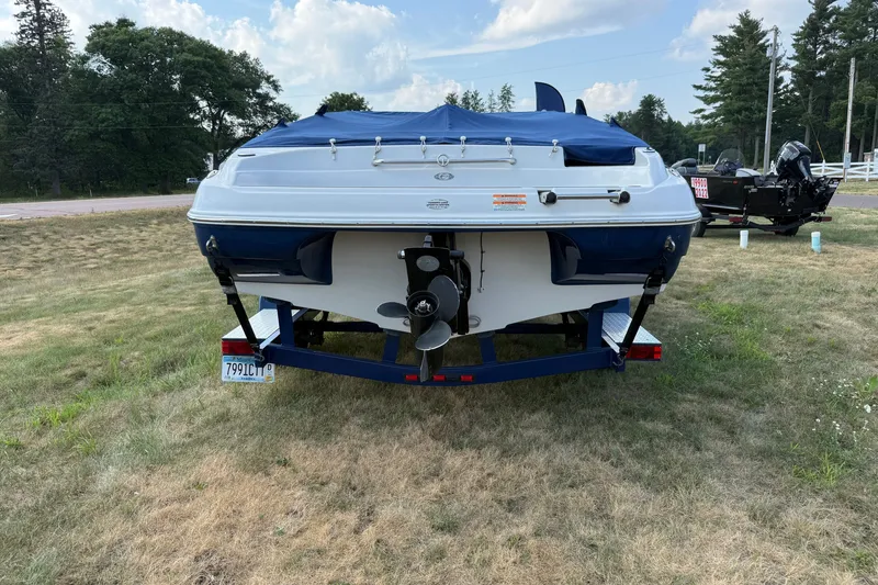 Slide: The Image of 2013 Crownline 21 SS boat on trailer, rear view, parked on grassy area. - 7