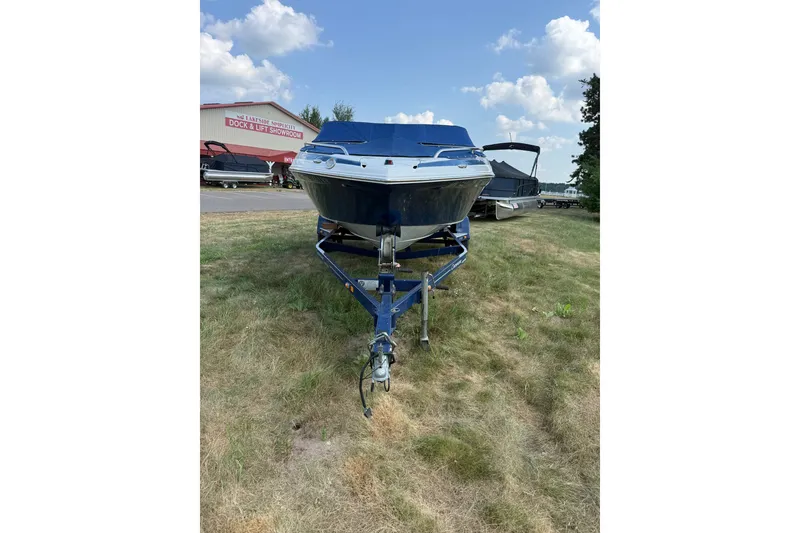 Slide: The Image of 2013 Crownline 21 SS boat on trailer, parked on grass near showroom. - 8