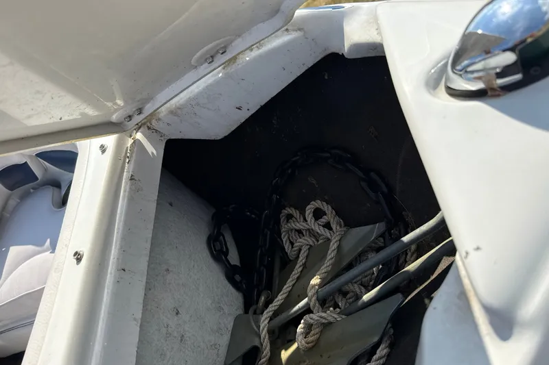 Slide: The Image of Open storage compartment on 2013 Crownline 21 SS boat with anchor and rope inside. - 30