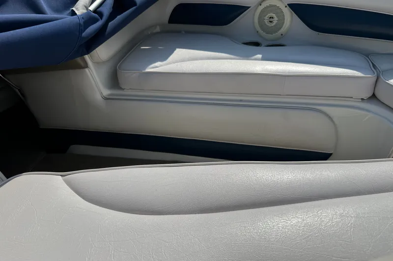 Slide: The Image of Interior seating of a 2013 Crownline 21 SS boat, featuring white upholstery and speaker. - 5