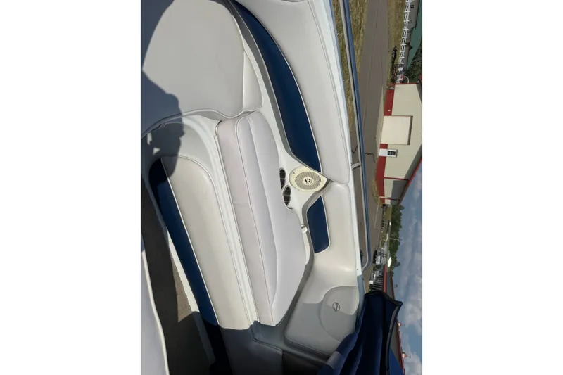 Slide: The Image of Interior of a 2013 Crownline 21 SS boat, featuring white and blue seating. - 16