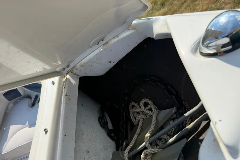 Slide: The Image of Open storage compartment on 2013 Crownline 21 SS boat with anchor and rope inside. - 13