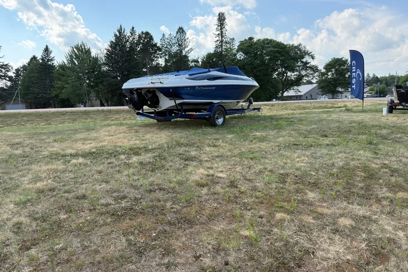 Slide: The Image of 2013 Crownline 21 SS boat on trailer in grassy area, under blue sky. - 9