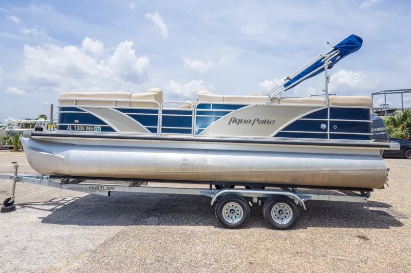 Slide: The Image of 2014 Aqua Patio 22 SLC pontoon boat on trailer under a clear sky. - 14