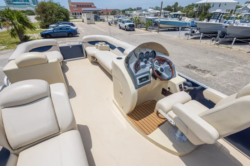 Slide: The Image of 2014 Aqua Patio 22 SLC boat interior with beige seating and steering console. - 19