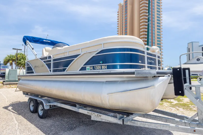 Slide: The Image of 2014 Aqua Patio 22 SLC pontoon boat on trailer, parked near tall building. - 9