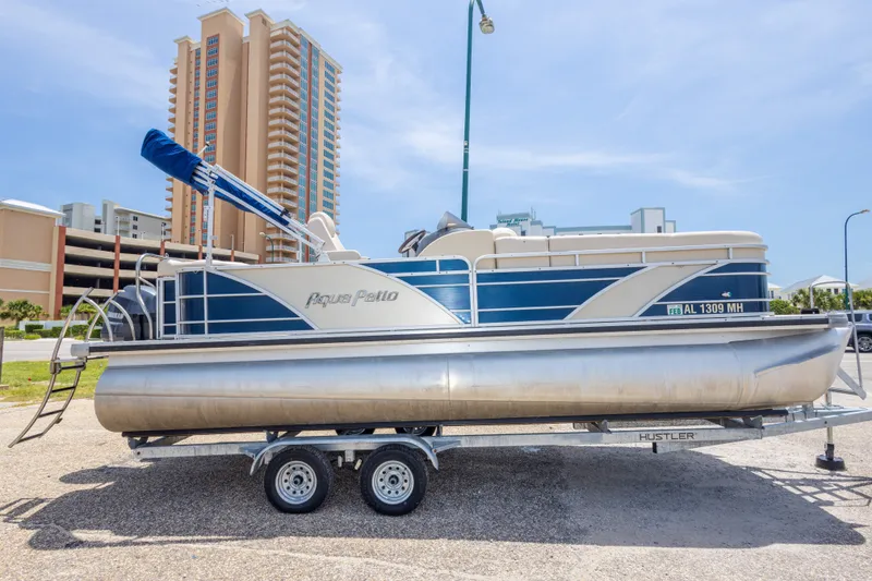 Slide: The Image of 2014 Aqua Patio 22 SLC pontoon boat on trailer, urban background. - 10