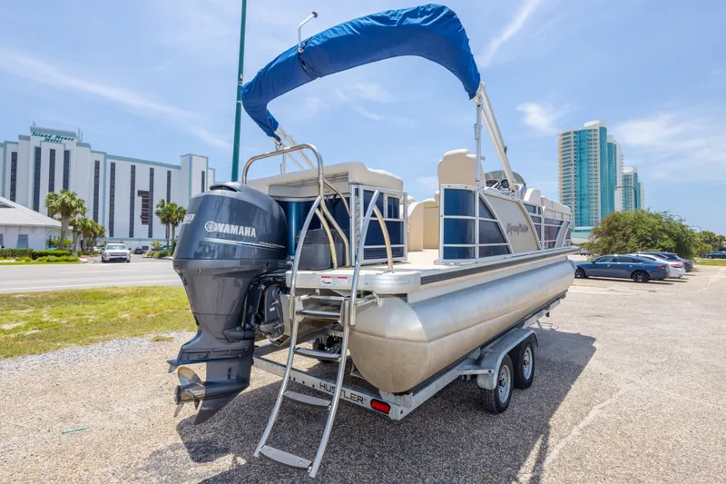 Slide: The Image of 2014 Aqua Patio 22 SLC pontoon boat with Yamaha engine on trailer, urban backdrop. - 11