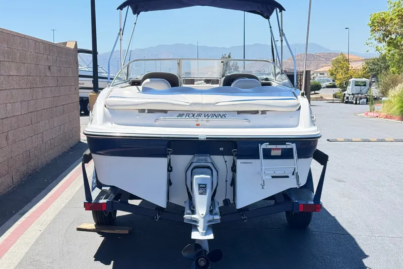 Slide: The Image of 2001 Four Winns 180 Horizon boat on trailer, rear view, parked outdoors. - 4