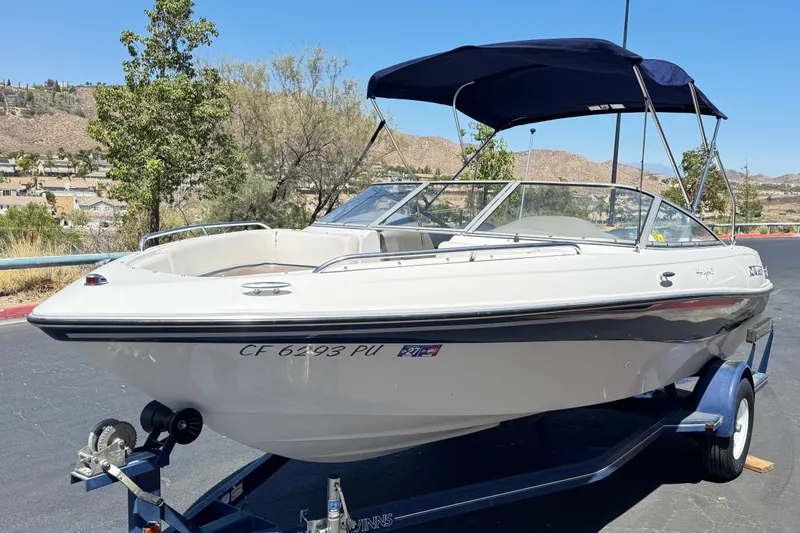 Slide: The Image of 2001 Four Winns 180 Horizon boat on trailer, parked outdoors under clear sky. - 3