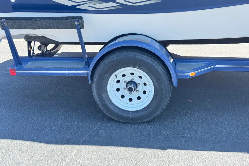 Slide: The Image of Trailer wheel of a 2001 Four Winns 180 Horizon boat on pavement. - 23