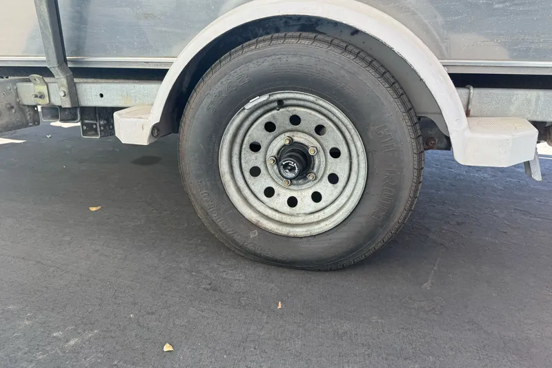 Slide: The Image of Trailer wheel of a 2000 North River 18 Mariner on asphalt surface. - 8