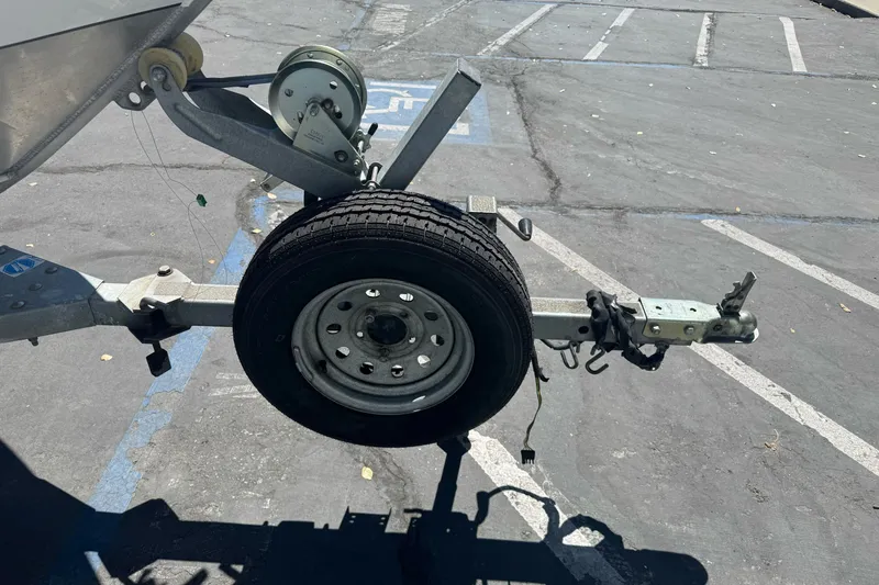 Slide: The Image of Trailer hitch and wheel of a 2000 North River 18 Mariner boat in parking lot. - 4