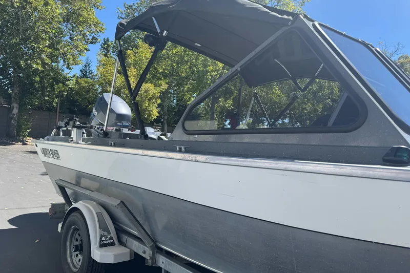 Slide: The Image of 2000 North River 18 Mariner boat on trailer, parked outdoors under clear sky. - 7