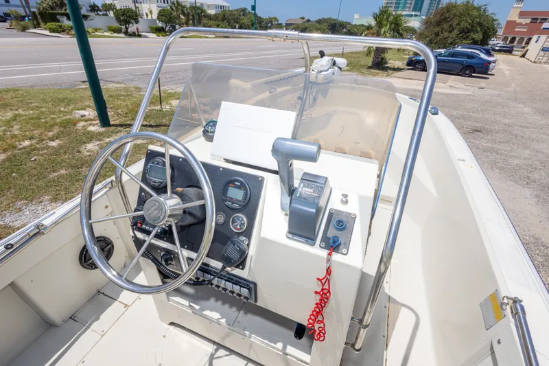 Slide: The Image of 1986 Boston Whaler 18 Outrage boat cockpit with steering wheel and control panel. - 32