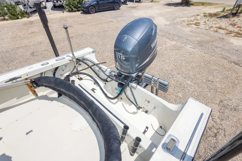 Slide: The Image of 1986 Boston Whaler 18 Outrage boat with Yamaha 115 outboard motor in a parking area. - 25