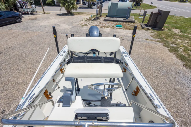 Slide: The Image of 1986 Boston Whaler 18 Outrage boat interior with steering wheel and seating, parked outdoors. - 28