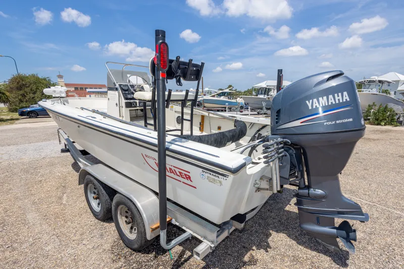 Slide: The Image of 1986 Boston Whaler 18 Outrage boat with Yamaha engine on trailer, parked outdoors. - 13