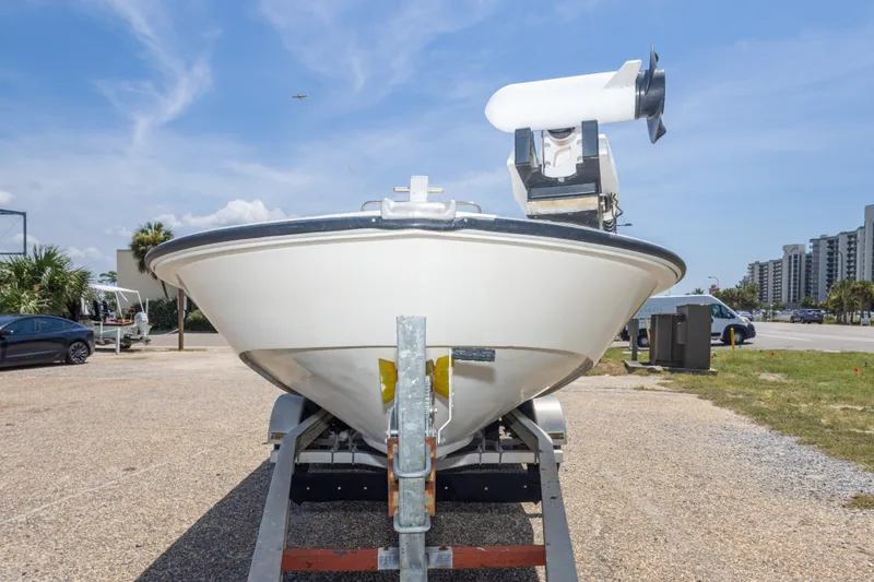 Slide: The Image of 1986 Boston Whaler 18 Outrage boat on trailer, parked outdoors under clear sky. - 17