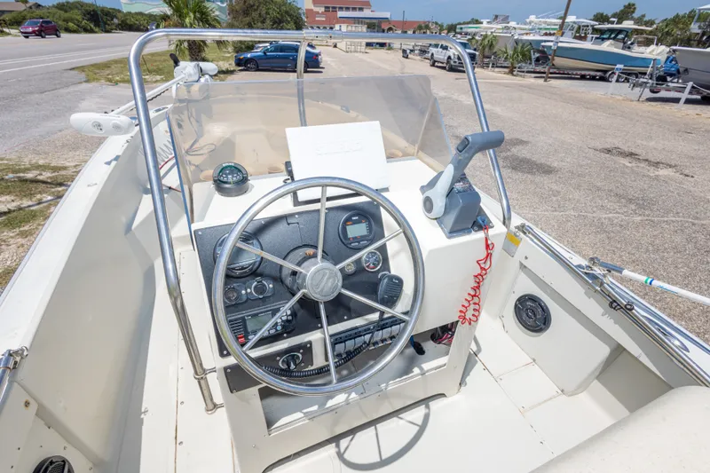Slide: The Image of 1986 Boston Whaler 18 Outrage boat cockpit with steering wheel and control panel. - 31