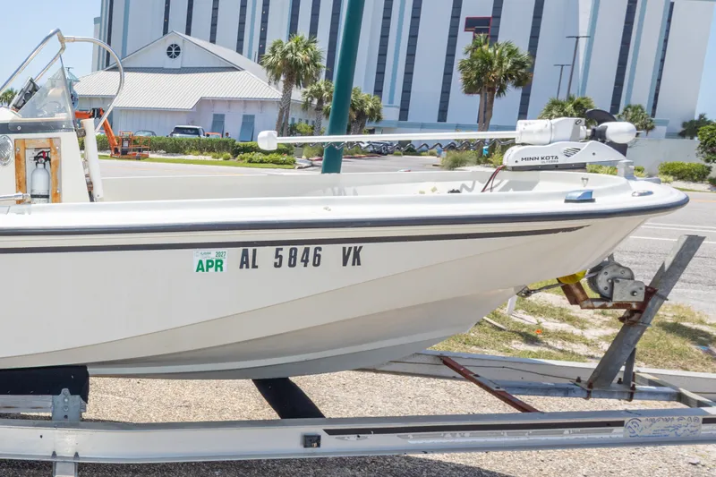 Slide: The Image of 1986 Boston Whaler 18 Outrage boat on trailer, parked near a building. - 35