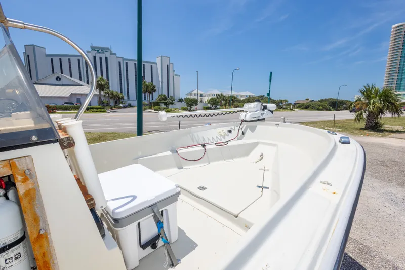 Slide: The Image of 1986 Boston Whaler 18 Outrage boat parked near modern buildings under clear blue sky. - 19