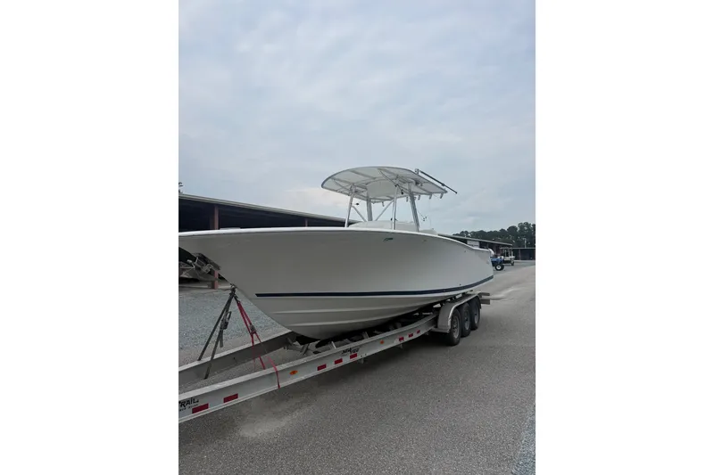 The Image of 2006 Southport 26 Center Console boat on a trailer, parked outdoors. - 2
