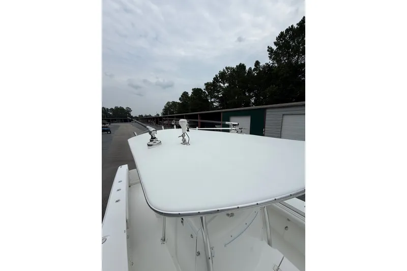 Slide: The Image of 2006 Southport 26 Center Console boat with T-top, docked near storage units. - 34