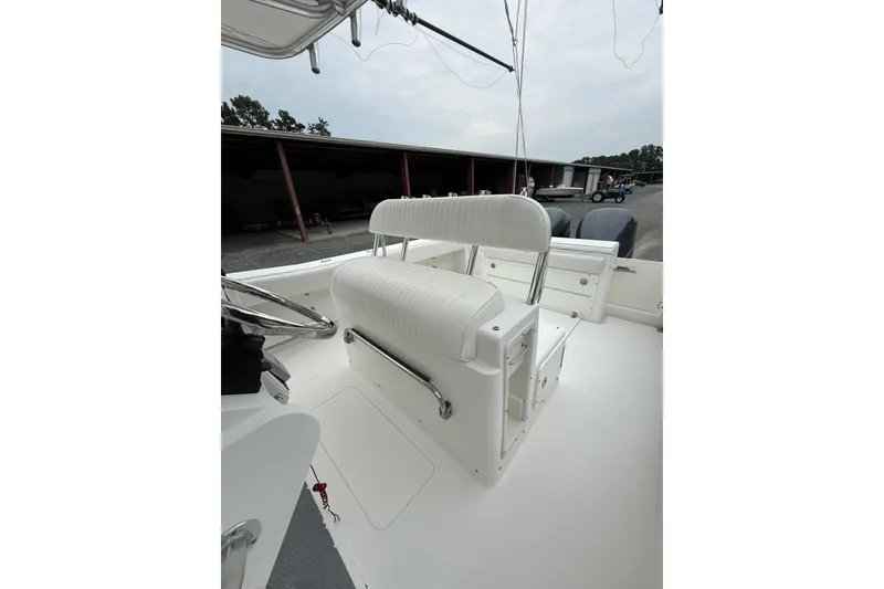 Slide: The Image of 2006 Southport 26 Center Console boat interior with white seating and steering wheel. - 16