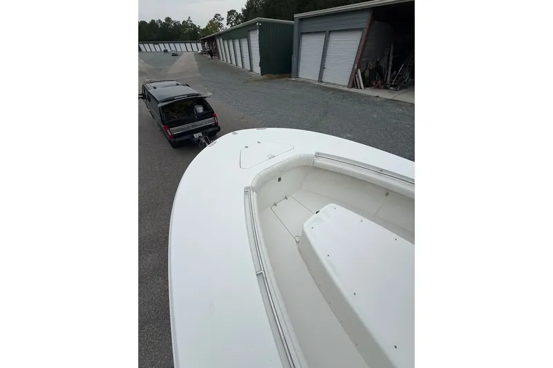 Slide: The Image of 2006 Southport 26 Center Console boat being towed by a vehicle near storage units. - 40