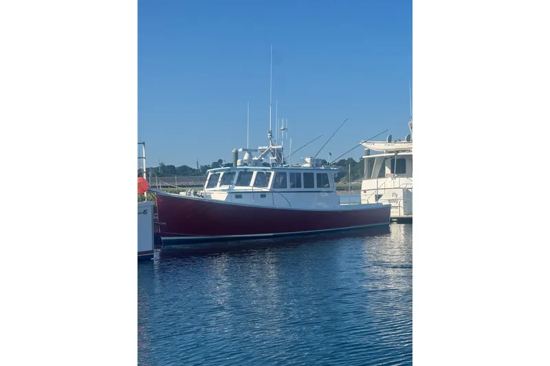 Slide: The Image of 2016 Young Brothers Downeast boat docked on calm water under clear blue sky. - 3