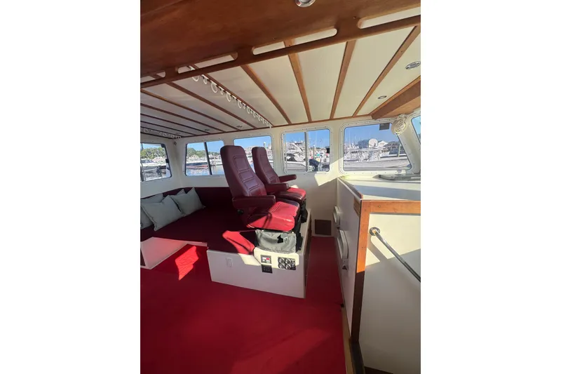 Slide: The Image of Interior of 2016 Young Brothers Downeast boat with red seating and wooden accents. - 18