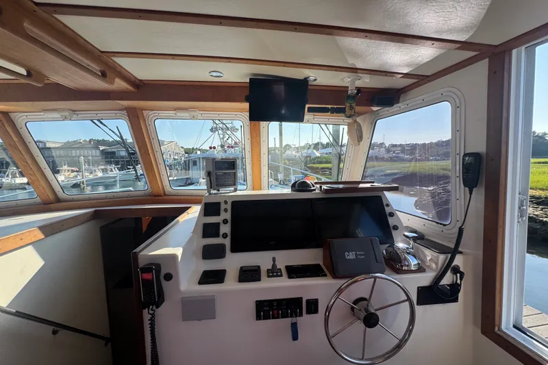 Slide: The Image of Interior view of 2016 Young Brothers Downeast boat cockpit with navigation equipment and steering wheel. - 15